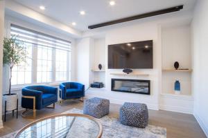 a living room with two blue chairs and a fireplace at Modern 4-Bed Townhome with Cinema & Roof Terrace in Oakville