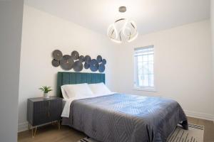 um quarto com uma cama e um lustre em Modern 4-Bed Townhome with Cinema & Roof Terrace em Oakville