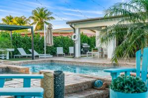 una piscina en un patio trasero con sillas y una casa en Oasis with Pool Spa Games 5BR L21 en Miami Gardens