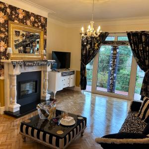 a living room with a fireplace and a chandelier at Glenmount Castleblayney in Castleblayney