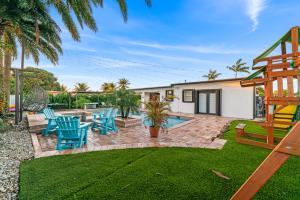 un patio trasero con piscina y sillas azules en Oasis with Pool Spa Games 5BR L21, en Miami Gardens