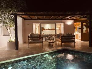 a house with a swimming pool and a living room at ROMEO AND JULIO SUMMER HOUSE in Mikonos