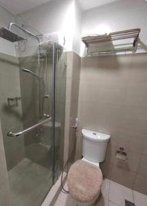 a bathroom with a glass shower and a toilet at Condotel-Shore 2 Residences MOA in Manila