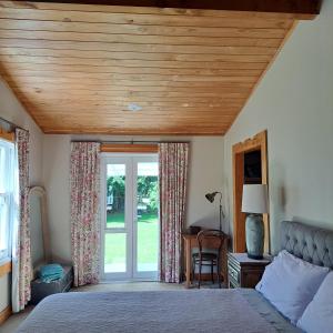 a bedroom with a bed with a wooden ceiling at The Homestead in Taupo