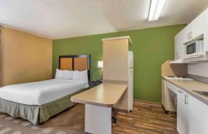 a small hotel room with a bed and a kitchen at Extended Stay America Select Suites - Chicago - Downers Grove in Downers Grove
