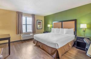 a hotel room with a large bed and a window at Extended Stay America Select Suites - Chicago - Downers Grove in Downers Grove