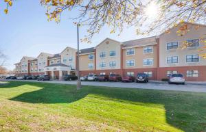 een groot gebouw met auto's geparkeerd op een parkeerplaats bij Extended Stay America Suites - Appleton - Fox Cities in Appleton