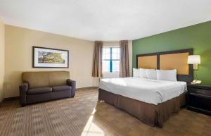 una camera d'albergo con letto e sedia di Extended Stay America Suites - Rochester - Henrietta a Ridgeland