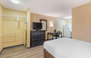 Schlafzimmer mit einem Bett, einem TV und einem Schreibtisch in der Unterkunft Extended Stay America Suites - St Louis - Westport - East Lackland Rd in Maryland Heights