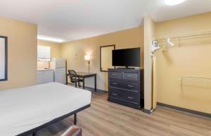 a room with a bed and a flat screen tv at Extended Stay America Suites - St Louis - Westport - East Lackland Rd in Maryland Heights