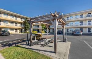 un banco bajo una pérgola de madera frente a un edificio en Extended Stay America Suites - St Louis - Westport - East Lackland Rd, en Maryland Heights