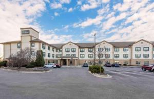Un gran edificio con coches aparcados en un estacionamiento. en Extended Stay America Select Suites - Chicago - Lisle, en Lisle