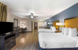 a hotel room with two beds and a flat screen tv at Extended Stay America Suites - Memphis - Germantown West in Memphis