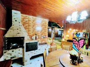 - un salon avec une cheminée et une table à manger dans l'établissement Mouton Blanc Campos do Jordão, à Campos do Jordão