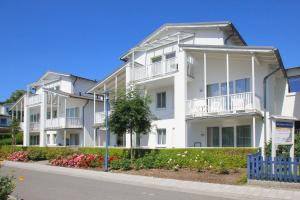 a white apartment building with balconies on a street at Balkon, gratis Nutzung vom AHOI Erlebnisbad und Sauna - Villa Karola FeWo 15 in Göhren +13 photos