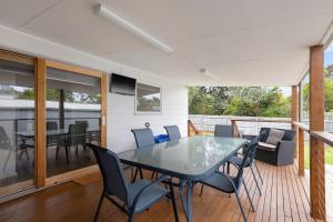 eine Terrasse mit Tisch und Stühlen auf einem Deck in der Unterkunft The Seascape Shack in Cowes