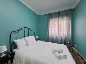 een blauwe slaapkamer met een bed met twee handdoeken erop bij Charme Lisboeta in Lissabon