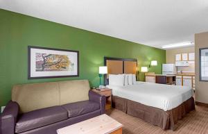 une chambre d'hôtel avec un lit et un canapé dans l'établissement Extended Stay America Select Suites - Tampa - Brandon, à Brandon