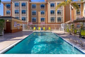 a swimming pool with chairs and a building in the background at Extended Stay America Premier Suites - Union City - Dyer St in Union City