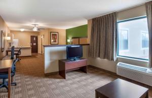 a hotel room with a tv and a desk with a computer at Extended Stay America Suites - Oakland - Emeryville in Oakland