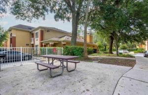 une table de pique-nique et un banc devant une maison dans l'établissement Extended Stay America Select Suites - Tampa - Brandon, à Brandon