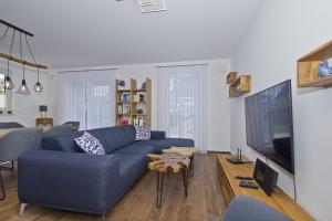 a living room with a blue couch and a tv at Ferienhaus Luna Haus - Terrasse, Garten, Sauna in Breege