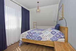 a bedroom with a bed with a blue and white quilt at Ferienhaus Luna Haus - Terrasse, Garten, Sauna in Breege