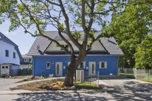 a blue house with a tree in front of it at Ferienhaus Luna Haus - Terrasse, Garten, Sauna in Breege