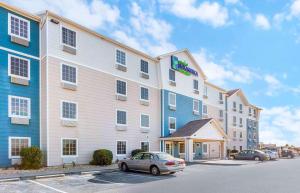 a large building with a car parked in front of it at Extended Stay America Select Suites - Wilmington - West in Wilmington