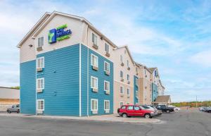 ein Hotel mit einem roten Auto auf einem Parkplatz in der Unterkunft Extended Stay America Select Suites - Jackson - South in Byram