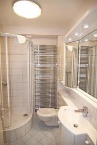 a bathroom with a toilet and a sink and a shower at Ferienwohnung Brise 1 in Wenningstedt