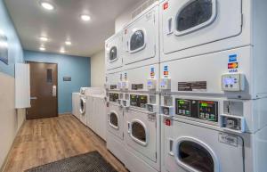 a laundry room with four washing machines on the wall at Extended Stay America Select Suites - Jackson - South in Byram