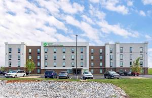 ein großes Gebäude mit Autos auf einem Parkplatz in der Unterkunft Extended Stay America Suites - Huntsville - Madison in Madison