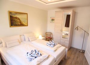 ein Schlafzimmer mit 2 Betten und Handtüchern darauf in der Unterkunft Ferienwohnung Lukas Bockelmann´s Hof (ebenerdig) in Westerland