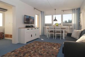 ein Wohnzimmer mit Couch und ein Esszimmer in der Unterkunft Odde Blick in Hörnum