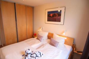 ヴェスターラントにあるFerienwohnung Austernfischerinのベッドルーム1室(白いシーツと枕のベッド1台付)