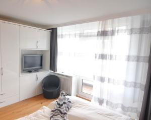 een slaapkamer met een bed, een tv en een raam bij Ferienwohnung Neptun in Westerland