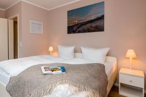 ein Schlafzimmer mit einem Bett, auf dem ein Buch liegt in der Unterkunft Sylt Liebt Dich 3 in Westerland