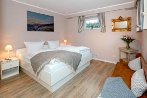 ein Schlafzimmer mit einem weißen Bett und einem Spiegel in der Unterkunft Sylt Liebt Dich 3 in Westerland