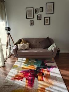 een bank in een woonkamer met een kleurrijk tapijt bij Oasis-Triana's Hallway in Camas