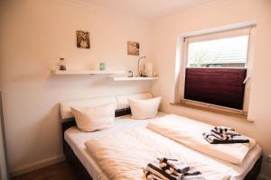 ein kleines Schlafzimmer mit einem Bett und einem Fenster in der Unterkunft Ferienwohnung Blaue Huis Erdgeschoß in Wenningstedt-Braderup
