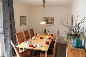 einen hölzernen Esstisch mit Stühlen und ein Esszimmer in der Unterkunft Ferienwohnung Blaue Huis Erdgeschoß in Wenningstedt-Braderup