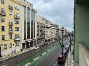 uitzicht op een straat met gebouwen en auto's bij Charme Lisboeta in Lissabon