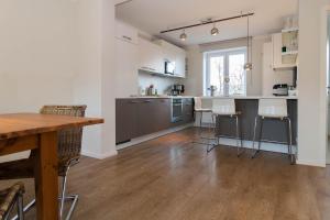 a kitchen with stainless steel appliances and a wooden floor at Haus Düne 9 in Hörnum