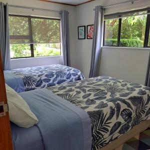a bedroom with two beds and two windows at The Homestead in Taupo