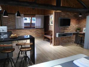 a kitchen and living room with a counter and a tv at Casa da Lagoa - Gasthaus Pomerode in Pomerode
