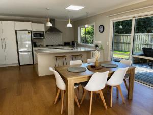 a kitchen and dining room with a wooden table and chairs at Walk to Town from this Modern and Warm Home in Central Cambridge Four Beds Available in Cambridge