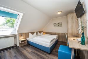 a bedroom with a bed and a desk and a television at Hotel-Restaurant Bauer-Keller in Greding