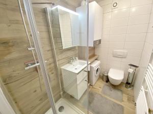 a bathroom with a shower and a toilet and a sink at Inselsonne Haus Inge - Fewo Inge in Breege in Breege +25 photos