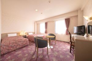 ein Hotelzimmer mit 2 Betten und einem TV in der Unterkunft Main Hotel - Vacation STAY 82549 in Miyakonojō